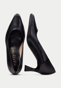 Svarta läderhögklackade skor med spetsig tå och en unik avsmalnad, utsvängd klack. Interiören har en vadderad sula för komfort.