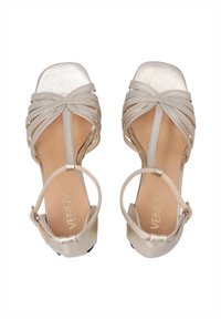 Silberne Riemchensandalen mit strukturiertem Obermaterial, offenen Zehen, gepolstertem Fußbett und verstellbarem Knöchelriemen, mit einem kleinen Absatz und glatter Oberfläche.