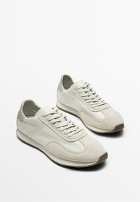 Pair of white leather and suede lace-up casual sneakers with rubber soles on a plain white background.