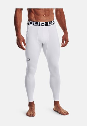 Leggings de sport blancs avec une taille élastique noire portant le texte "UNDER ARMOUR". Comprend un petit logo sur la jambe inférieure. Tissu lisse.