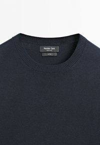 Granatowy bawełniany sweter z okrągłym dekoltem, prążkowanym kołnierzem oraz wszytą od wewnątrz przy dekolcie metką marki Massimo Dutti.