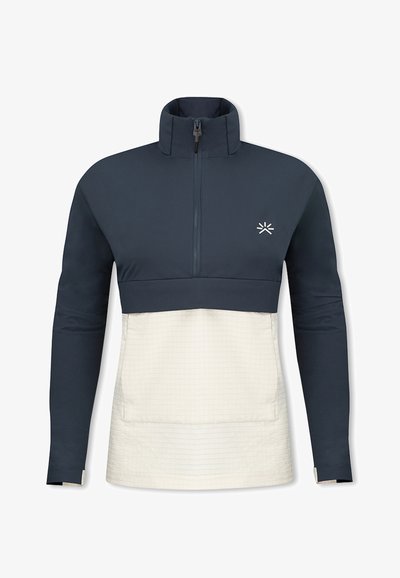 Marinblå och krämfärgad tröja med hög krage, halvdragkedja framtill och rutmönster på den nedre delen. Litet logotyp på bröstet.