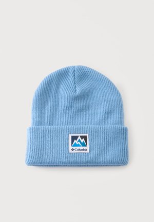 Bonnet tricoté bleu clair avec revers plié et un patch rectangulaire montrant un logo de montagne et le nom de la marque Columbia.