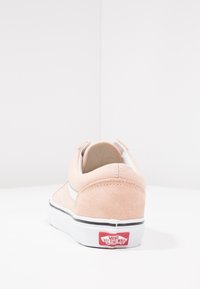 Ljust rosa mockasinsneakers med rundad form. Har en vit sidostrip och svart sula, med "Vans Off The Wall"-logotypen.
