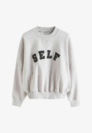 Grå sweatshirt med V-hals, ribbede manchetter og kant. Har sort broderet skrift "SELF" hen over brystet. Blød, fleece-lignende tekstur.