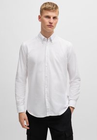 Witte button-up shirt van katoen. Voorzien van een klassieke kraag, lange mouwen en een klein logo op de borst. Glad textuur.