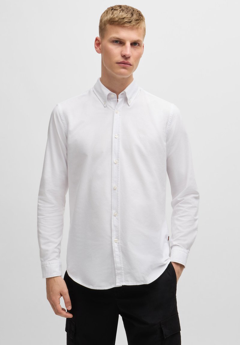 Witte button-up shirt van katoen. Voorzien van een klassieke kraag, lange mouwen en een klein logo op de borst. Glad textuur.