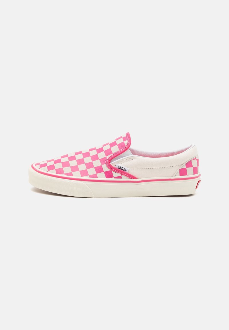 Sneaker à enfiler avec un motif à damier rose et blanc, semelle blanche et étiquette logo Vans sur le côté.