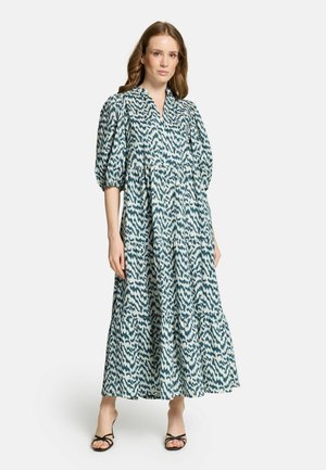 Rochie cu manșete puff, în nuanțe de teal și alb cu un model, decolteu în V, fustă în straturi și material ușor, asortată cu sandale negre cu barete.
