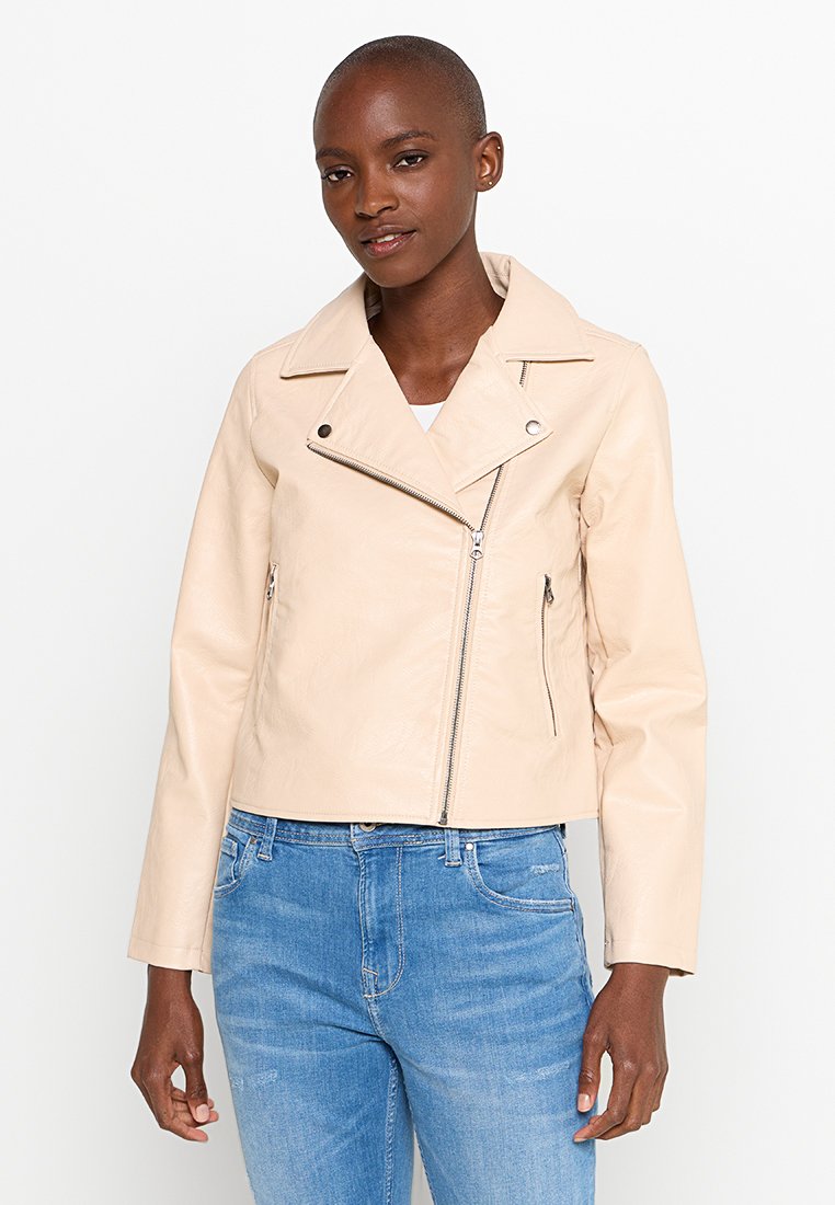 Chaqueta de moto de piel beige con cuello con muesca, cremallera asimétrica y dos bolsillos laterales con cremallera. Superficie texturizada, diseño ajustado.
