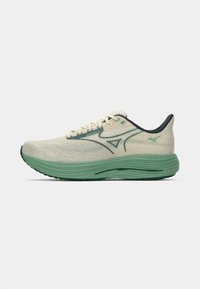 Baskets de course avec un dessus beige clair, des accents verts et une finition texturée. Elles possèdent une semelle épaisse et rembourrée pour un meilleur soutien.