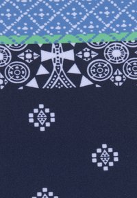 Tissu multicolore avec un motif de losanges bleu en haut, une bande verte au milieu et une section inférieure en marine foncé ornée de motifs géométriques blancs.