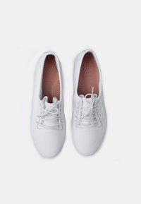 Fehér bőr fűzős cipők sima felülettel, lekerekített orral és perforált béléssel a légáteresztés érdekében. Puha rózsaszín belső bélés.