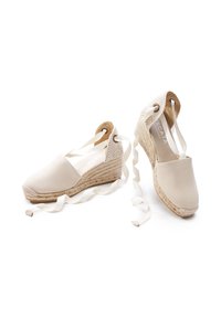 Espadrillas in tela beige con tacchi in juta intrecciata, caratterizzate da una punta arrotondata e lacci in raso, completate da un accento sul tacco testurizzato.