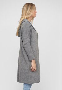 Grauer, strukturiertes Strick-Cardigan mit Kapuze, offenem Vorderteil und drei Viertel langen Ärmeln. Das Design bietet eine lockere Passform und seitliche Schlitze.