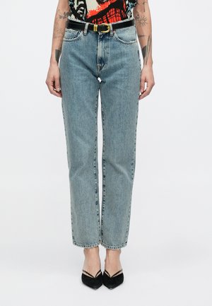 Τζιν παντελόνι από ανοιχτόχρωμο ντένιμ με ίσια γραμμή, κλασικό σχέδιο πέντε τσεπών και μαύρη ζώνη με χρυσή αγκράφα.