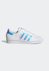 White sneakers with iridescent blue and pink stripes, textured toe cap, and rubber sole. Features classic three-stripe design.