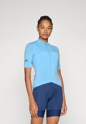 Light blue cycling jersey with short sleeves and a half-zip, paired with navy cycling shorts featuring a padded insert.