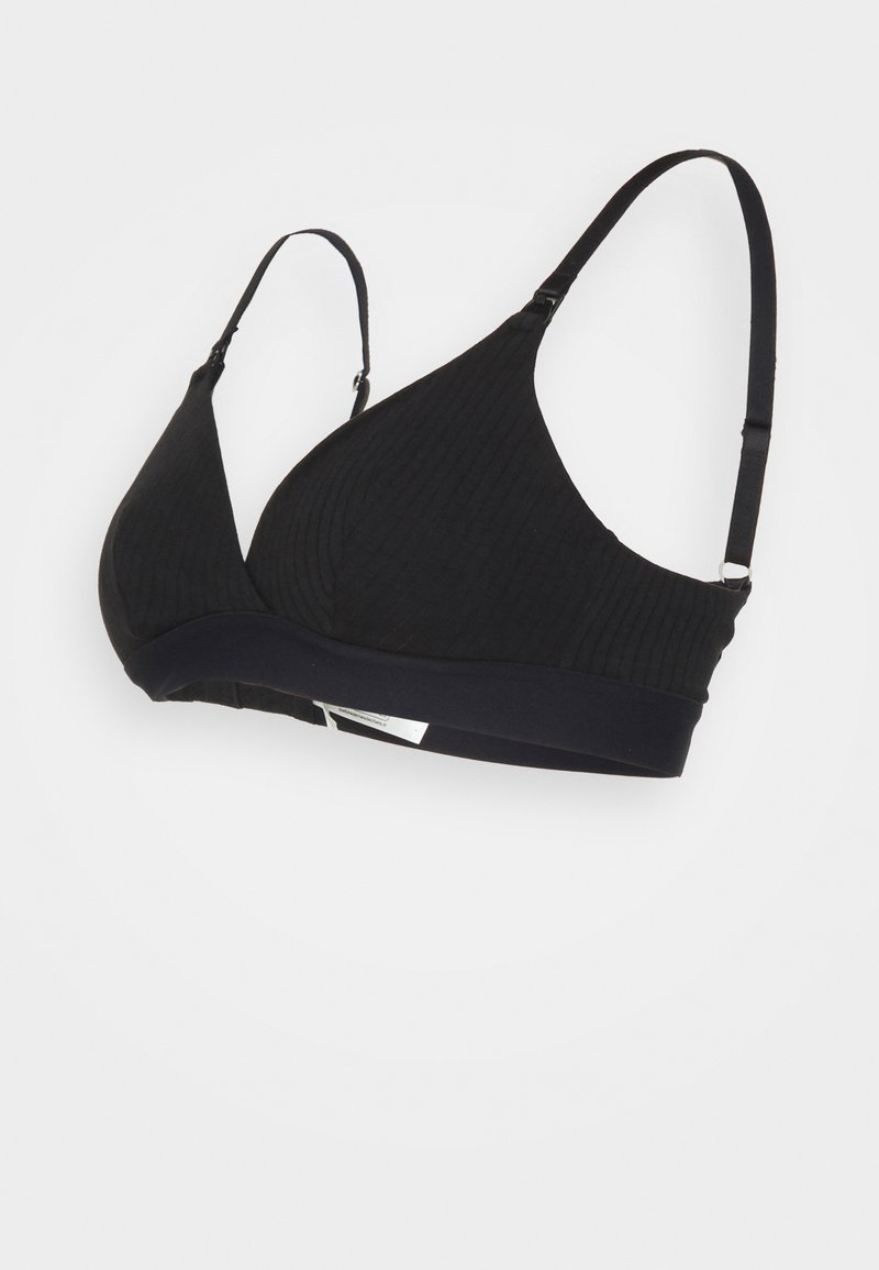 Black ribbed bralette with adjustable straps and a wide underband. Textured fabric with a smooth finish, featuring minimal hardware accents.