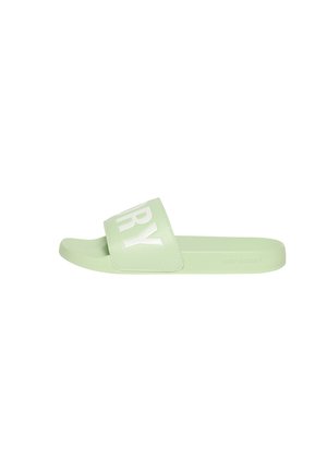 Lichtgroene slidesandalen met een brede band met grote witte deels zichtbare letters op de band.