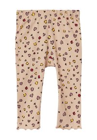 Lichtbeige leggings met een golvende zoom, met een speels patroon van harten en stippen in tinten van roze, geel en zwart. Zacht materiaal.