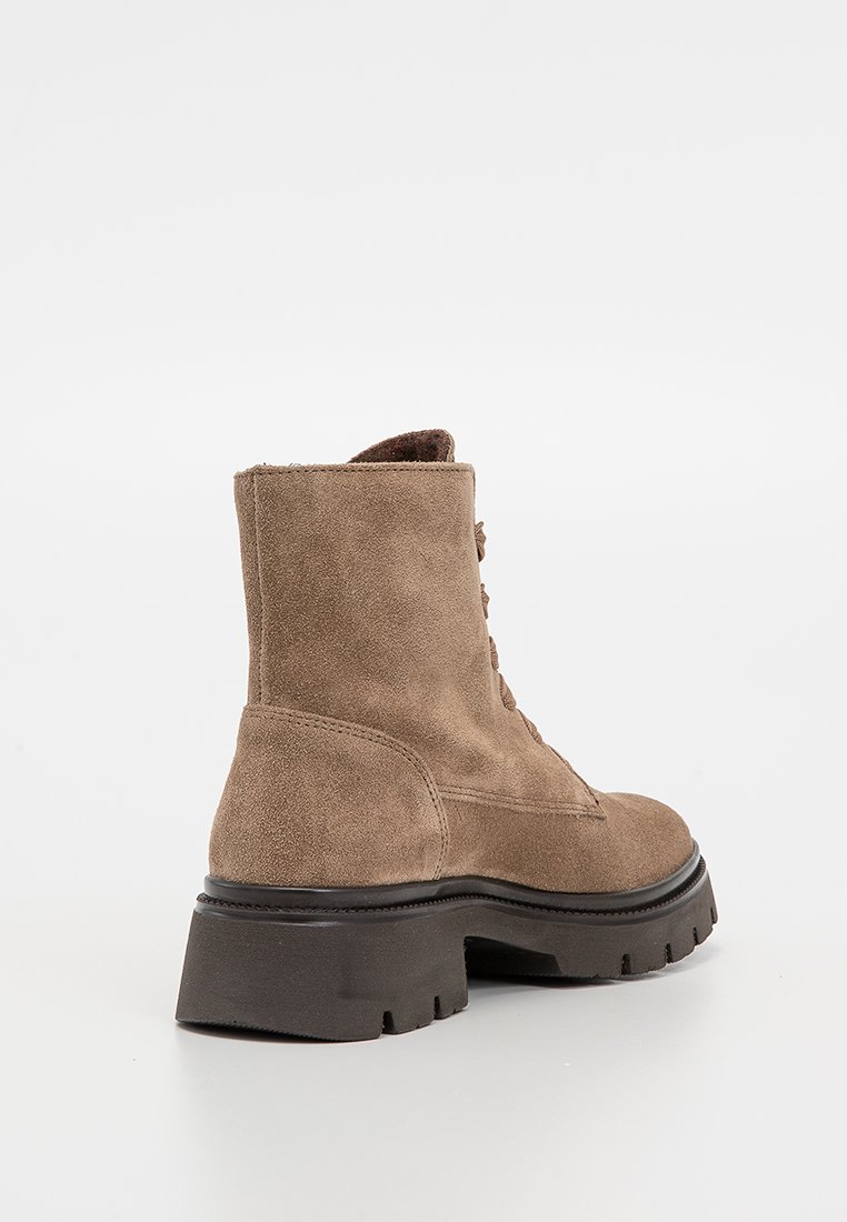 Bruine suède enkellaars met een gestructureerde afwerking, vetersluiting en stevige zwarte zool. Voorzien van een lipje aan de achterzijde voor gemakkelijk aan- en uittrekken.