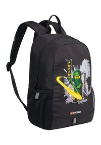 Rucsac negru cu un grafic de ninja, având accente verzi și galbene. Include buzunare laterale din plasă și o mânere de transport deasupra. Material rezistent.