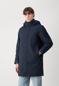 Marine vandtæt parka med frontlynlås, hætte og sidelommer. Har justerbare manchetter og en diskret logoaccent på ærmet.