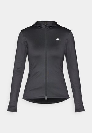 Fekete, cipzáros kapucnis pulóver hosszú ujjal, sima textúrával és kis fehér logóval a mellkasán. Feszes fazon és oldalsó zsebek jellemzik.