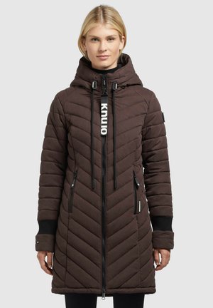 Brown quilted jacket with a hood, featuring slim vertical and diagonal lines, zippered pockets, and a branded pull tab on the zipper.