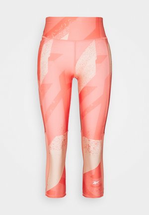 Leggings Capri dans une teinte corail avec un motif géométrique, une taille haute et un tissu lisse et extensible pour le confort et la liberté de mouvement.