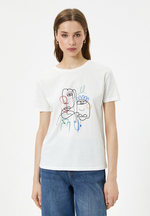 T-shirt en coton blanc avec un design d'art linéaire abstrait en noir, rouge, vert et bleu. Manches courtes, col rond, coupe décontractée.