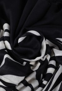 Schwarz-weißer gestreifter Stoff aus einem weichen, leichten Material mit abwechselnd kräftigen Streifen und einer glatten Textur.