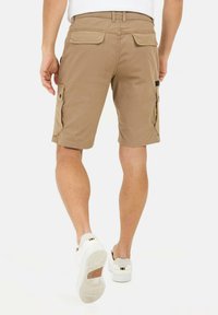 Tans kleur cargoshorts met zijzakken, lichtgewicht katoenen stof, riemlussen en een rechte zoom. Draag ze met witte sneakers.