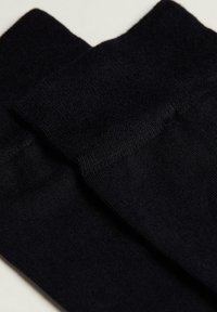 Sorte sokker lavet af blødt, strækbart materiale; har en glat, strikket tekstur med en ribbet kant. Simpelt, sømløst design uden mønstre.