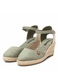 Sandalias de cuña de gamuza verde con un tacón de yute trenzado, punta en forma triangular, correa ajustable en el tobillo y un acento decorativo de botón.