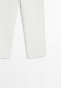 Lower half of white pants with straight legs on a plain white background.