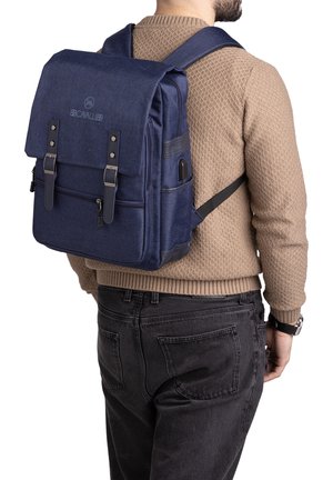 Zaino in tessuto blu navy con doppie patte superiori, tasca frontale con zip, spallacci regolabili e dettagli in pelle nera. Presenta un esterno testurizzato.