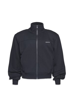 Czarna polarowa kurtka na zamek z wysokim kołnierzem, prążkowanymi mankietami i pasem. Posiada poziomą szew na klatce piersiowej oraz logo po lewej stronie.