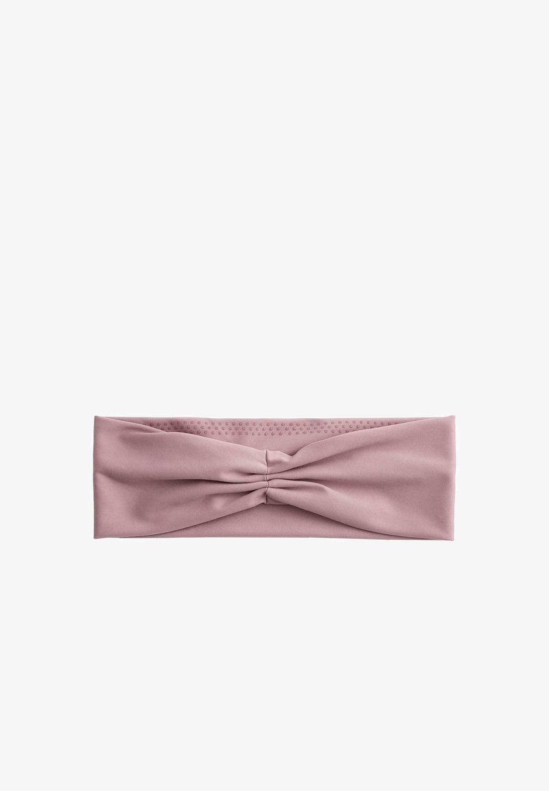 Bandeau en tissu rose poudre extensible avec un détail torsadé froncé au centre et de subtils points texturés sur le côté intérieur.