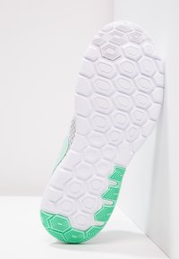 Suela de zapato con un patrón hexagonal blanco y acentos verdes, presentando un diseño texturizado y un lado superior de color gris claro.