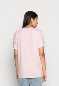 Light pink cotton t-shirt with a crew neck, short sleeves, and a relaxed fit, featuring a smooth texture and simple design.