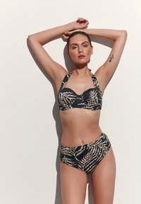 Juodas bikinis su viršumi, kuris laiko kaklą, su suktos dizaino ir smėlio spalvos organiniais raštais, derinamas su aukštu juosmeniu apatinėmis dalimis, užtikrinančiomis aprėptį ir palaikymą.