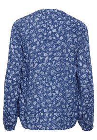Langärmlige Bluse in Marineblau mit einem zarten Blumenmuster in Hellblau. Verfügt über eine lässige Passform und elastische Bündchen. Glatte Stofftextur.