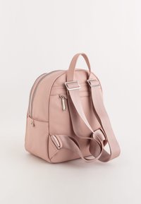 Liten rosa ryggsäck i texturerat material, med dubbla dragkedjor, ett handtag upptill och justerbara remmar. Inkluderar sidofickor.