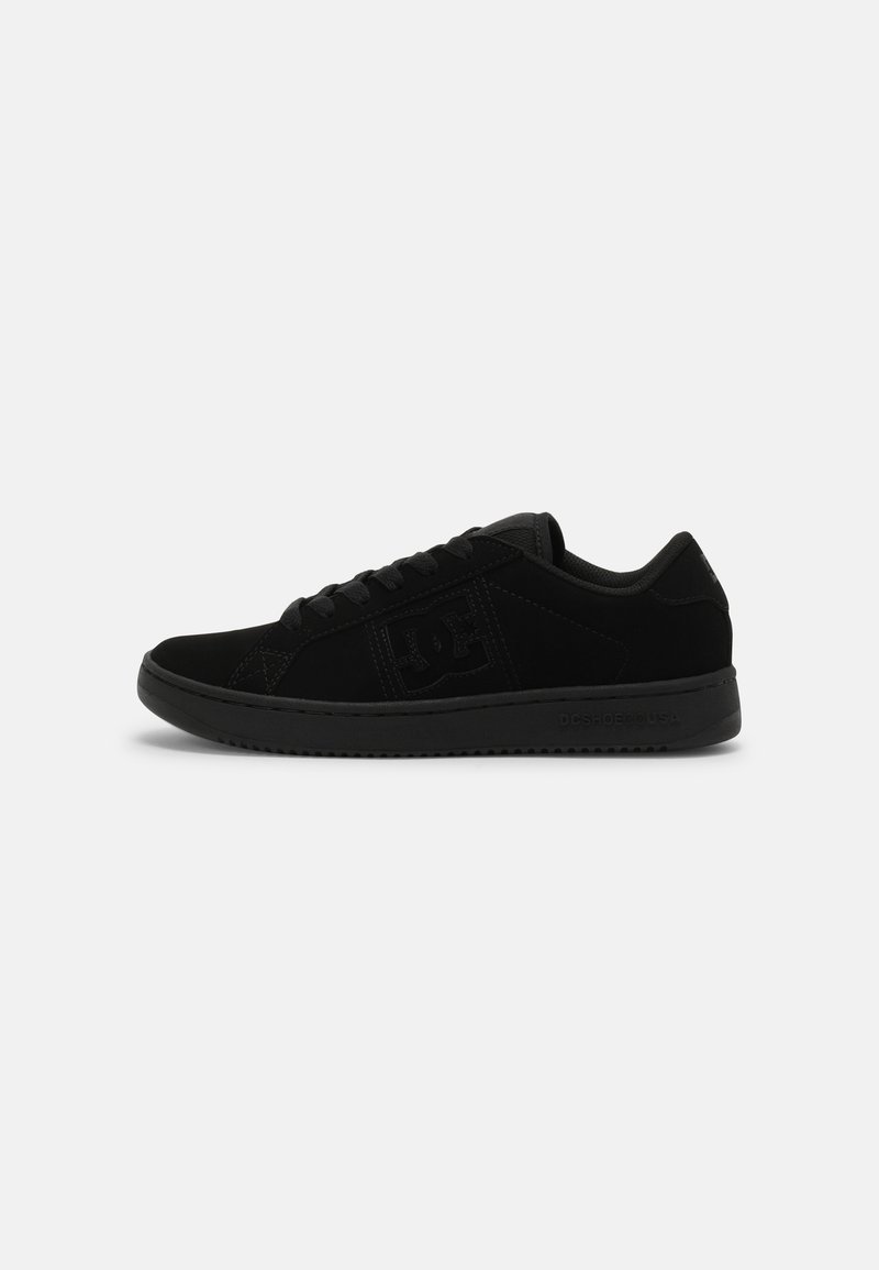 Zapatillas de ante negro con una suela de goma plana, cordones redondos y un logo elevado en el lado y el talón, con un diseño aerodinámico.