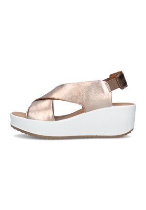 Sandalo zeppa con cinturini incrociati in oro rosa metallizzato, cinturino elastico sul tallone e suola piattaforma bianca spessa con grip testurizzato.