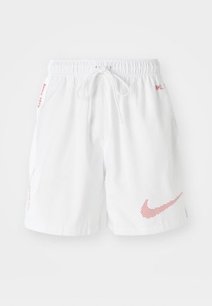 Shorts Nike blancs avec une taille élastique et un cordon de serrage, ornés d'accents de logo en pointillés rouges et de texte sur les côtés. Tissu léger.