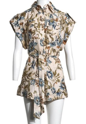 Robe-chemise manches courtes à imprimé floral, ceinturée, avec col et poches avant sur un buste de mannequin blanc.