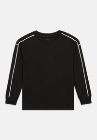 Melna gara piedurkne T-kreklā ar apaļu kakla izgriezumu, kas apvilkta ar kontrastējošām gaismas bežām sānu svītrām gar pleciem un piedurknēm.